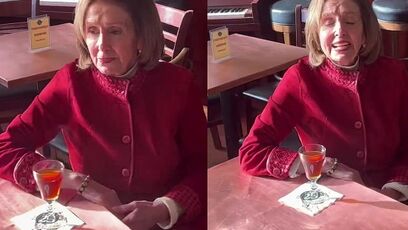 Sad-looking Pelosi spotted sitting alone, sipping a drink, handlers remove someone who approached her