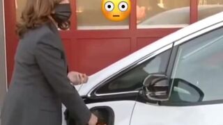 Kamala Harris holds EV charger like she's pumping gas