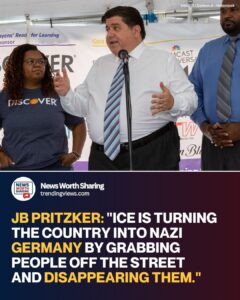 Illinois Governor JB Pritzker speaking at a microphone, gesturing while flanked by two people at an event.